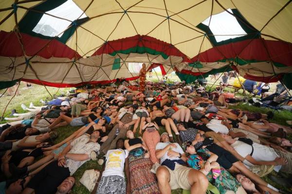 Festivalgoers take part in a laughter-yoga workshop in the Healing Field.  PA