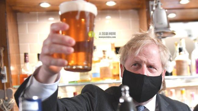 Boris Johnson holding a pint of beer in a pub