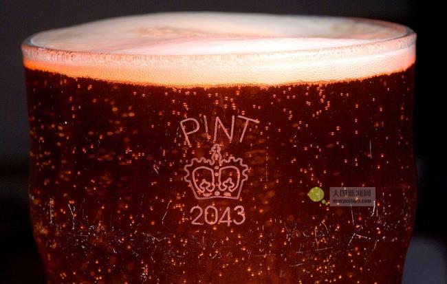 A full pint glass with a crown crown stamp