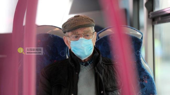 A elderly man wears a protective face mask on a bus in Belfast