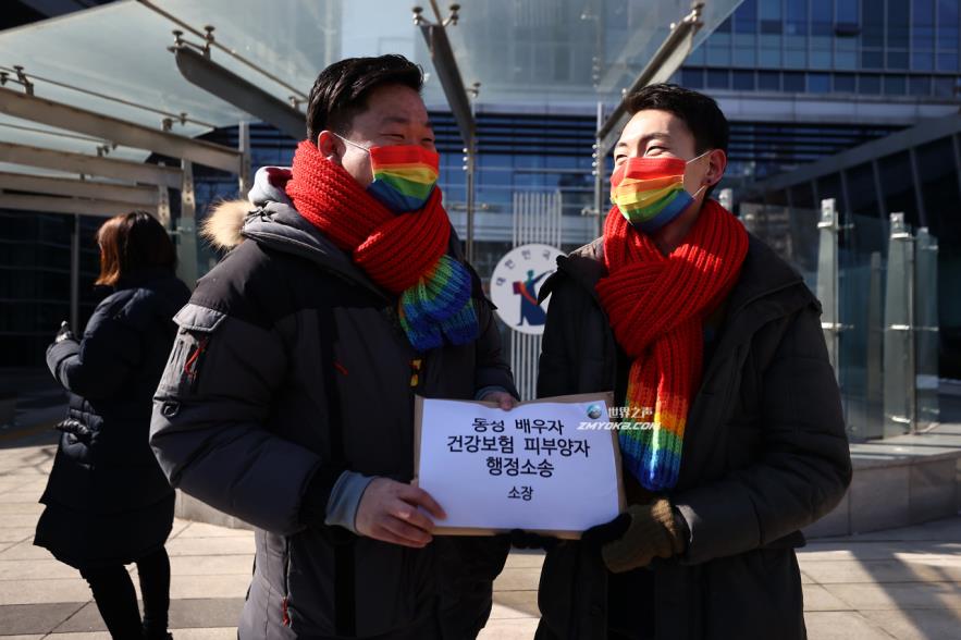 So Seong-wook (L) and Kim Yong-min, a South Korean gay couple, stand in front of the Seoul Administrative Court in southern Seoul on Feb. 19, 2021, before filing an administrative lawsuit against the Natio<em></em>nal Health Insurance Service. (Yonhap)