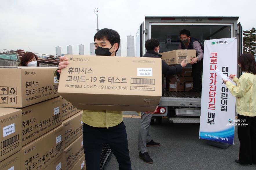 Daegu city officials help move boxes of rapid antigen test kits on Jan. 5. (Yonhap)