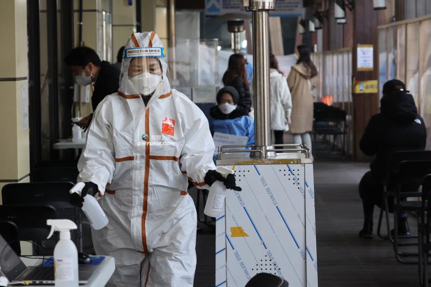A health worker sprays disinfectant at a COVID-19 testing station in Seoul on Monday. (Yonhap)