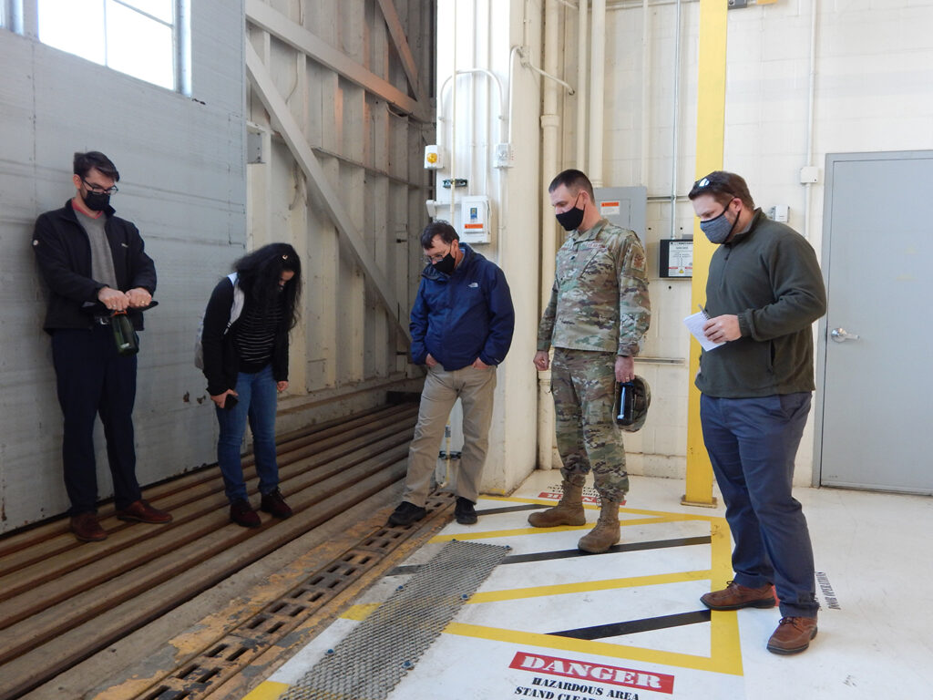 Washington University graduate students (left to right) Kyle Collier, Astha Bhatnagar, and Cam Loyet talk with 375th Civil Engineer Squadron's Kenneth Cavanaugh (middle) and squadron commander Lt. Col. Paul Fredin a<em></em>bout water drainage inside Hangar 3. On Aug. 12, 2020, over five inches of rain fell within two hours on Scott Air Force ba<em></em>se causing damage to several buildings including the hangar. The students discussed several potential solutions to prevent future flooding inside the hangar. (Photo: Courtesy of Christine Spargur)