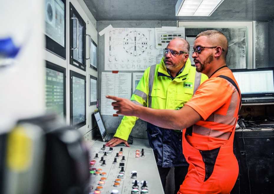 Two men operating a tunnel boring machine