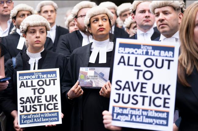 Barristers in wigs hold posters outside Old Bailey